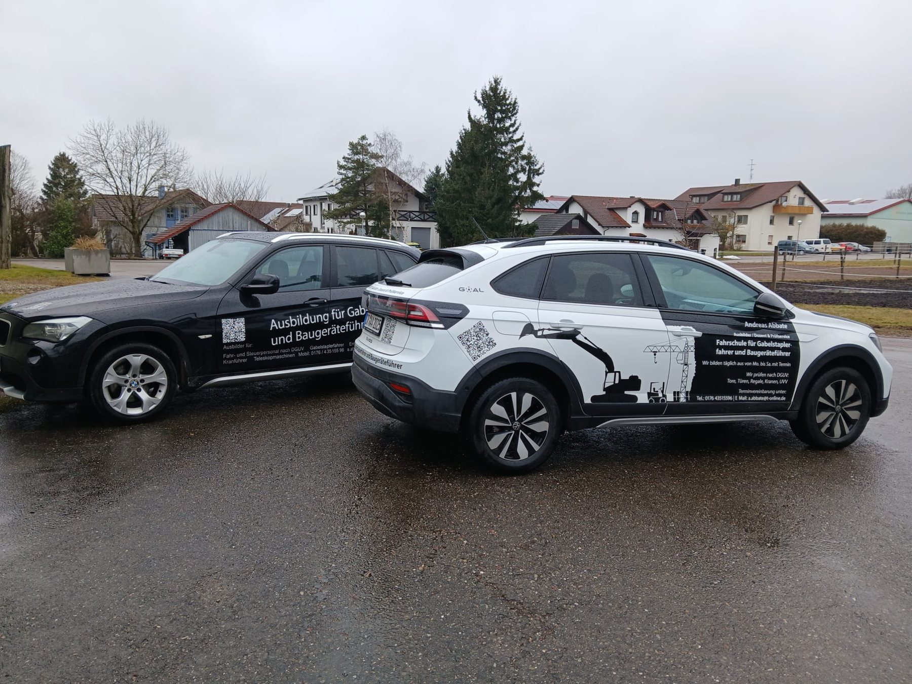 Zwei beschriftete Schulungsfahrzeuge auf einem Platz